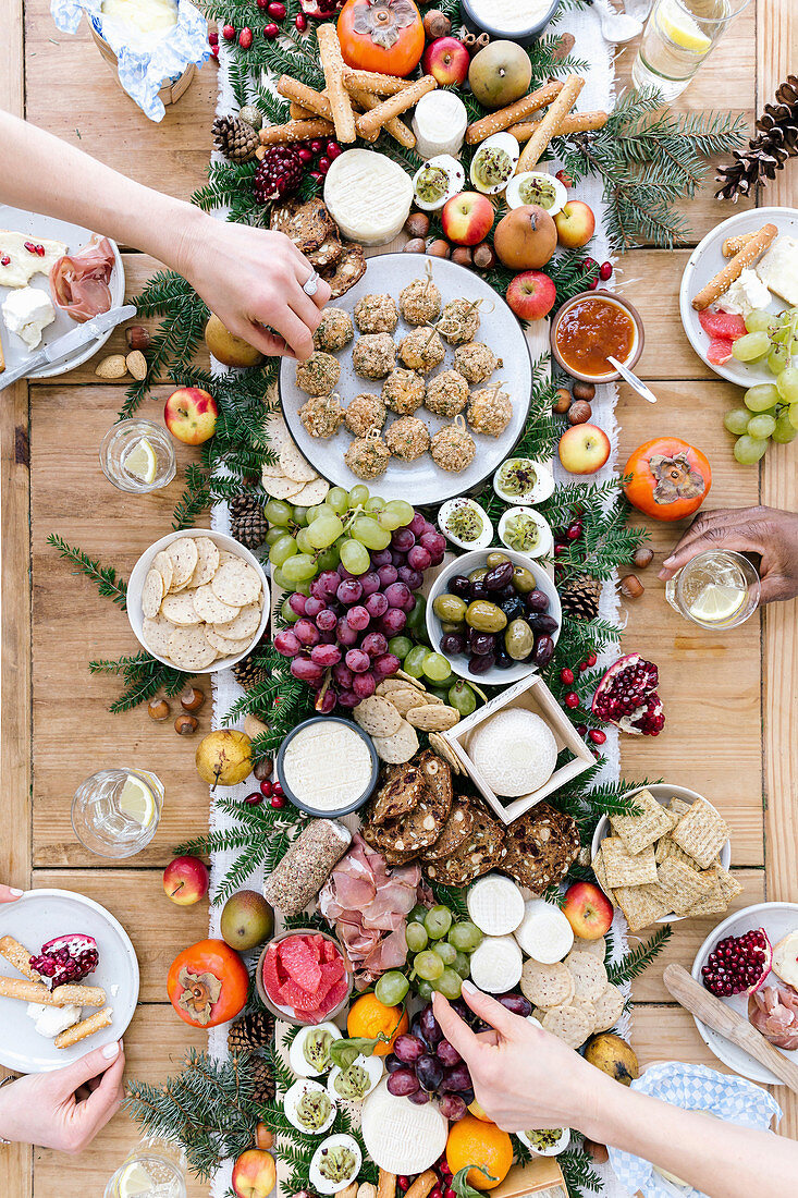 A savoury selection board for friends, with cheese, grapes, olives, breads, ham, eggs and fruit