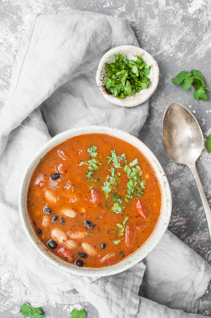 Vegane Bohnensuppe mit Chilischoten, Tomaten und Koriandergrün