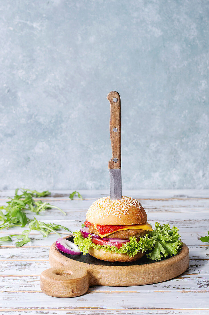 Selbstgemachter klassischer Burger mit Zwiebeln, Tomatensauce und Käse