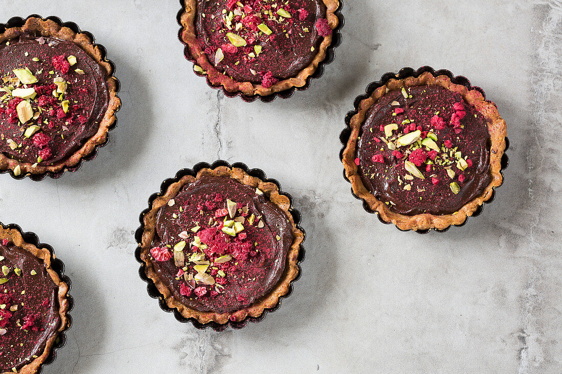 Schokotarteletts mit Gewürzen, getrockneten Himbeeren und Pistazien