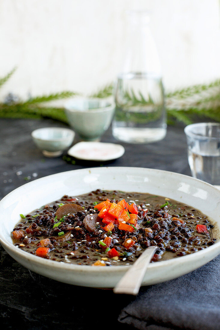 Black Lentil Sesame Coconut Soup served with sparkling water