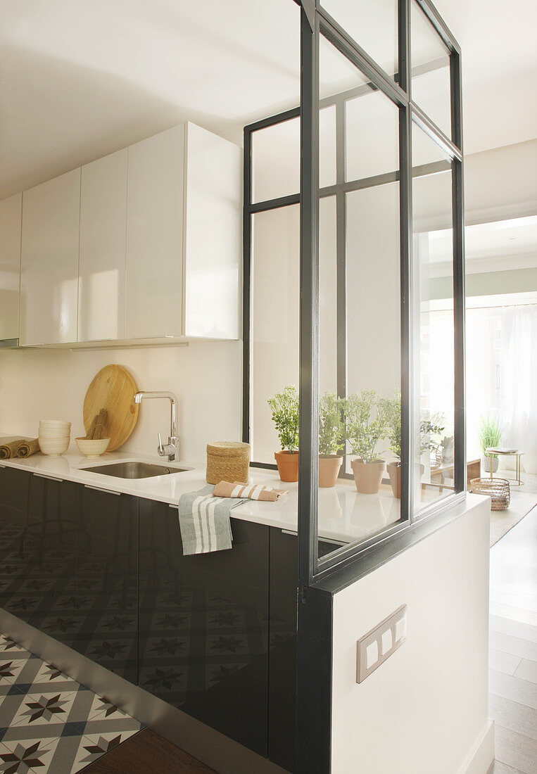 Halboffene Küche mit halbhoher Glaswand als Raumteiler