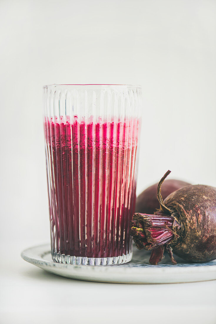 Fresh morning beetroot smoothie or juice in glass, white background