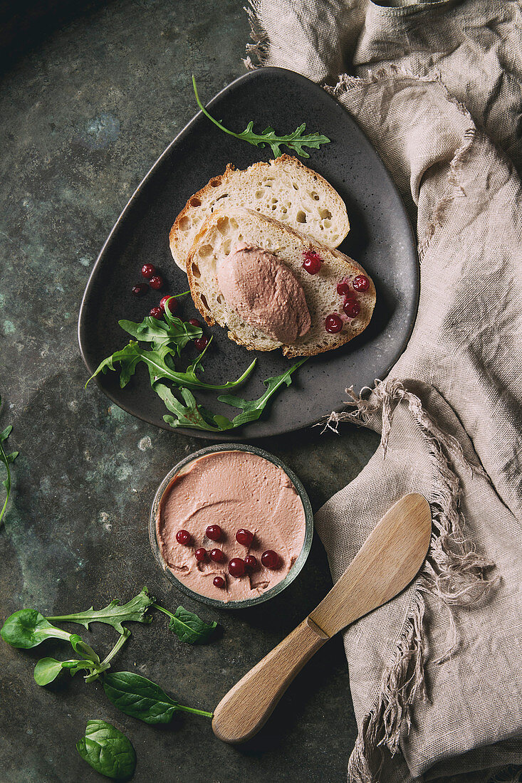 Hühnerlebercreme serviert mit Cranberries und Brot (Aufsicht)