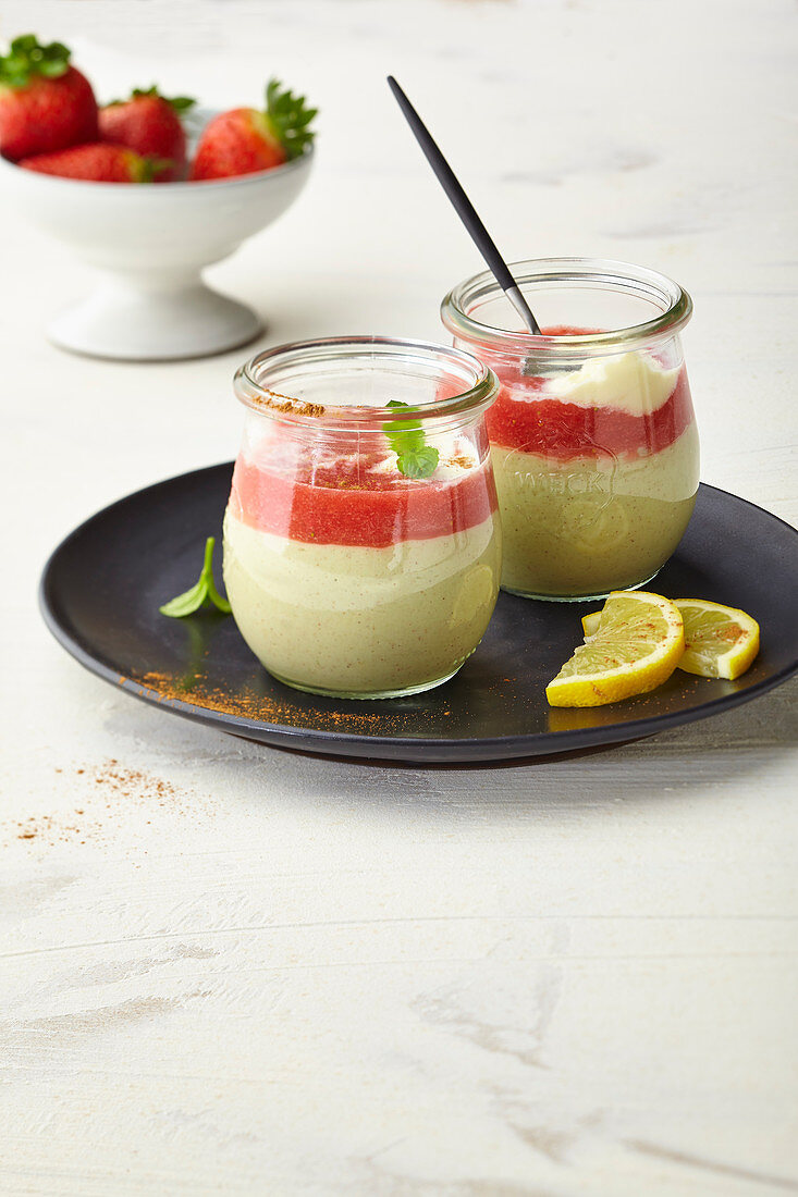 Sweet avocado cream with strawberry sauce, layered in glasses