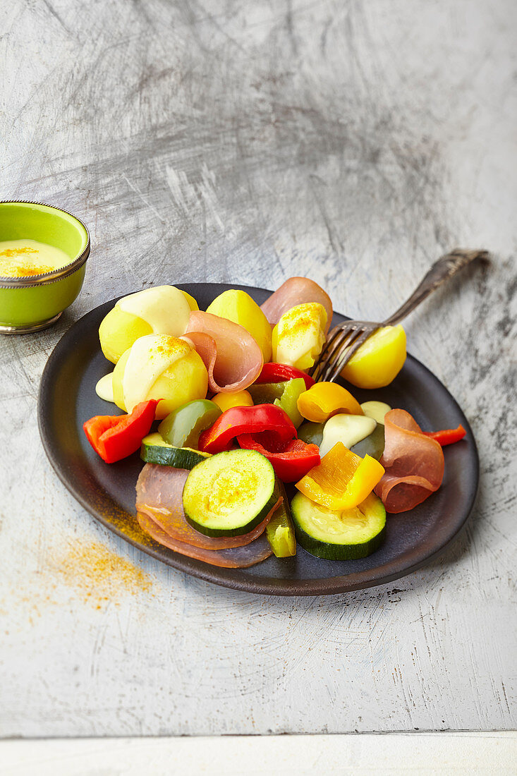 Potatoes with colourful vegetables and turmeric sauce