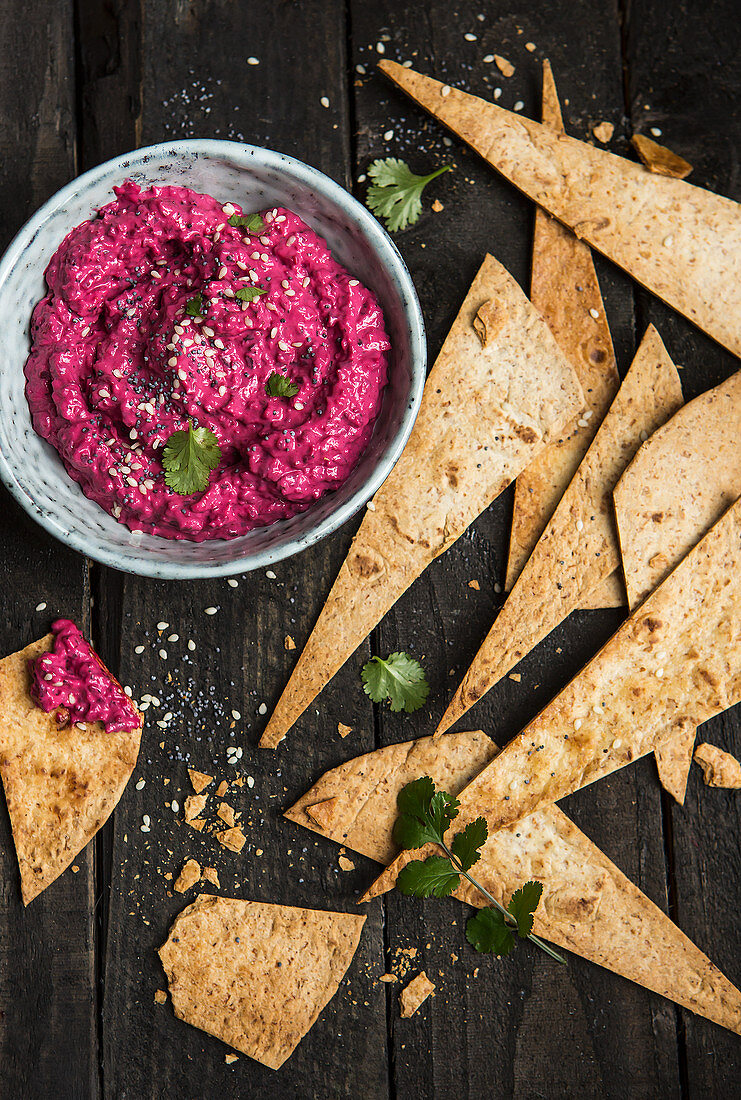 Beetroot hummus with tortilla chips for dipping (top view)