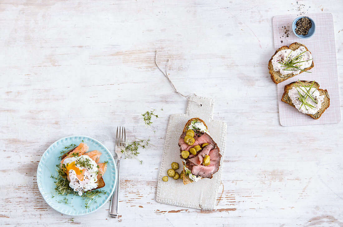 Toast with poached egg and salmon, pumpkin seed bread with ham cream, and baguette with roast beef