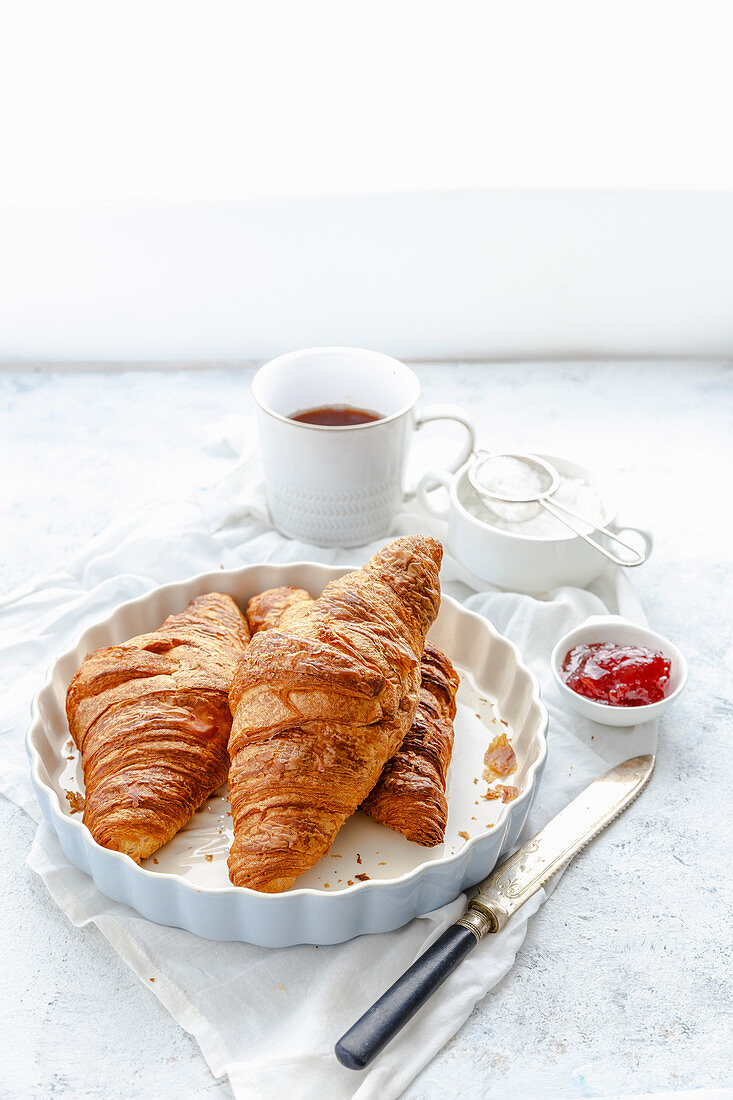 Croissants mit Marmelade und Kaffee zum Frühstück