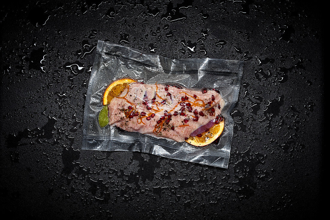 Duck breast with orange slices and spices in a sous vide bag