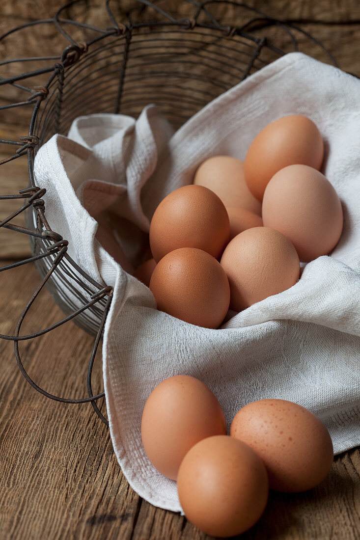 Fresh eggs on a cloth in a wire basket