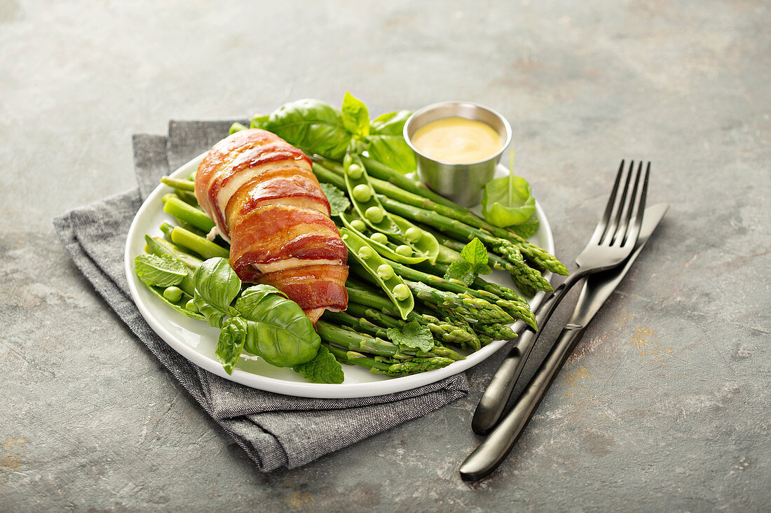 Bacon wrapped chicken breast with asparagus and spring peas