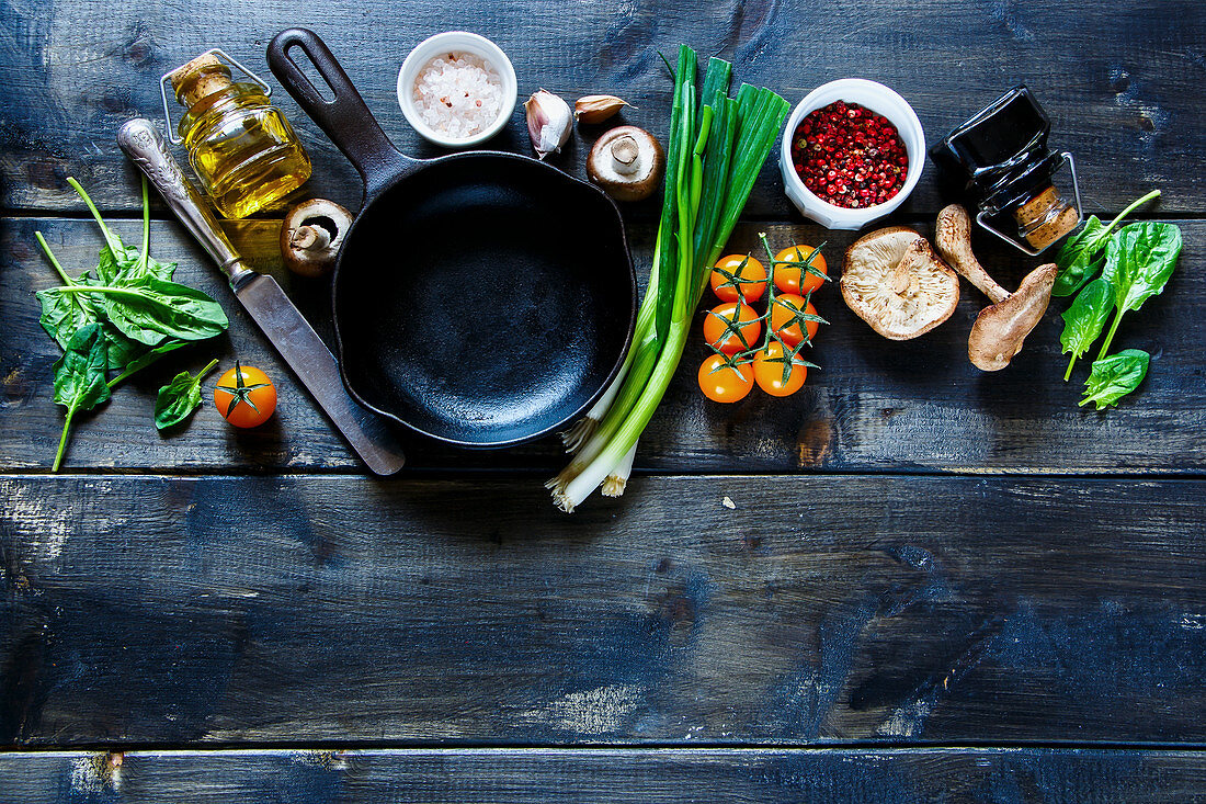 Vegetarian organic ingredients and seasoning on rustic kitchen table with olive oil and balsamic vinegar