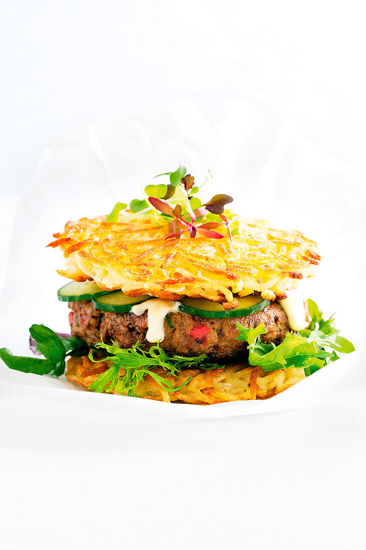 Ramen-Burger mit Gurke und Salat vor weißem Hintergrund