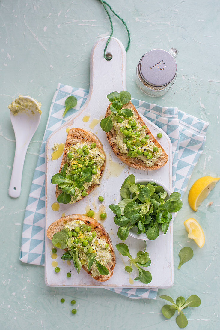 Crostini mit Frischkäse, Erbsen, Feldsalat und Zitrone