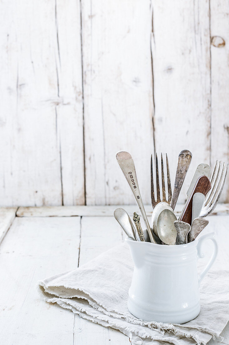 Vintage cutlery in a white porcelain jug