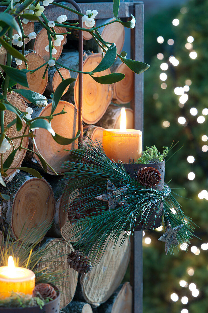 Christmas Candles In Hanging Pot On Firewood Shelf