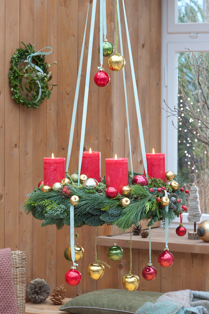 Hängender Adventskranz mit roten Kerzen