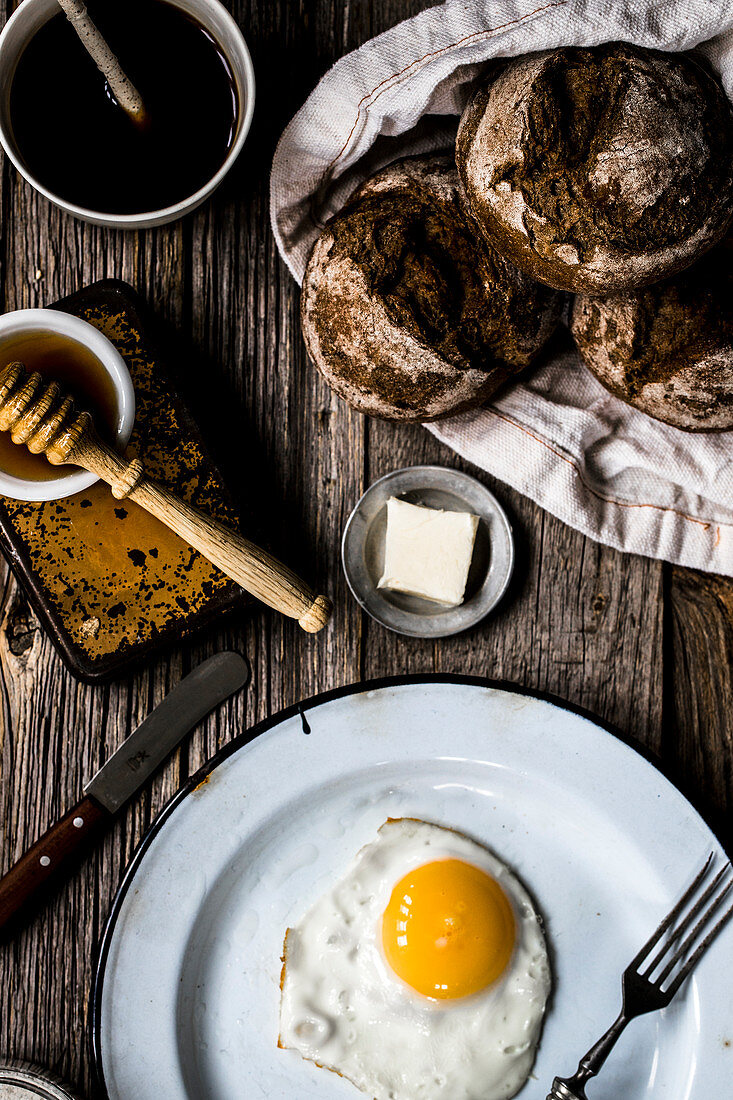 Fried egg with rolls, butter and honey