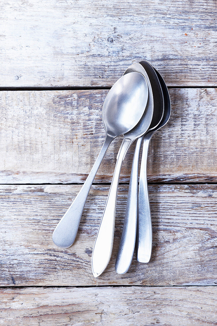 Several soup spoons on a wooden background