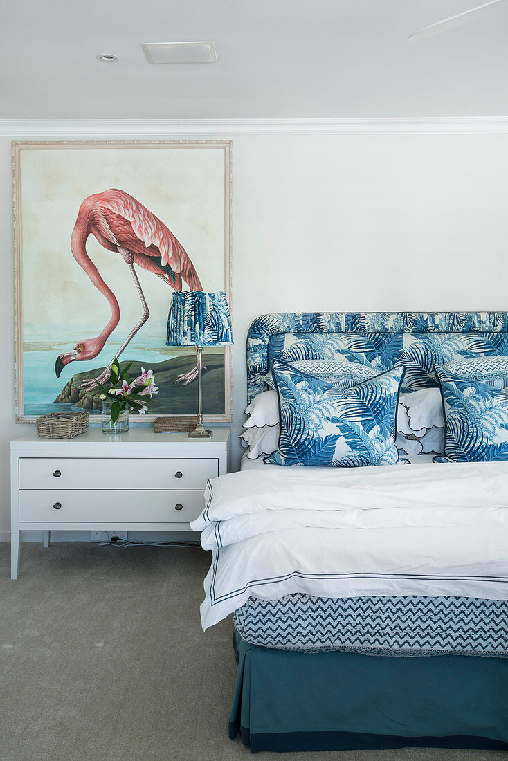 Picture of flamingo in bedroom with blue and white jungle-patterned textiles