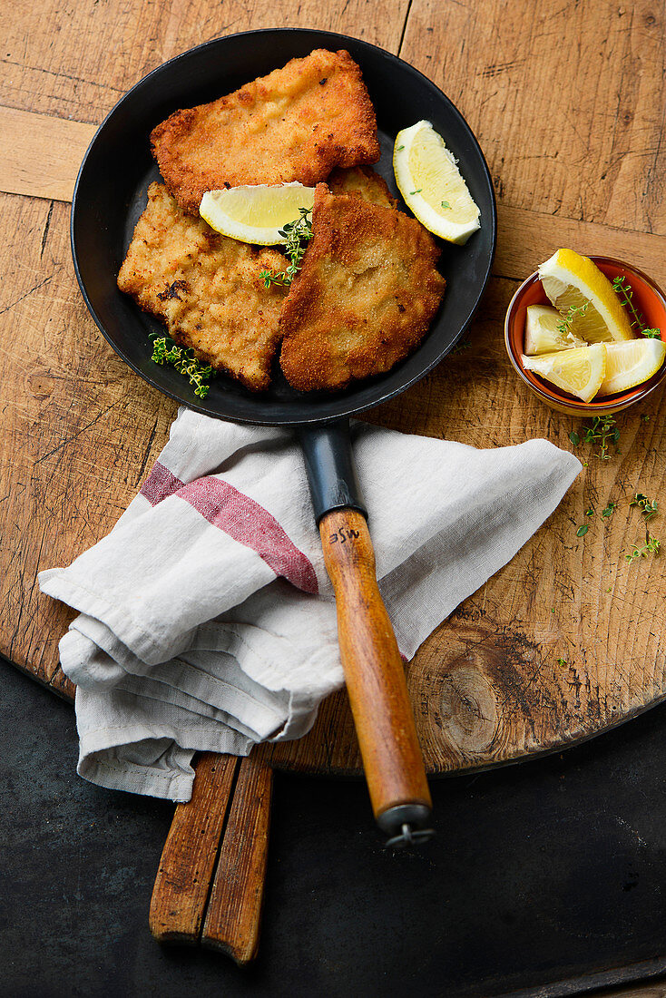 Breaded pork schnitzel in a pan (top view)