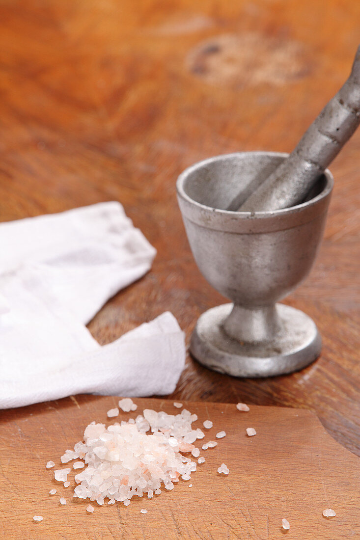 Grobes Salz auf Tisch und Mörser
