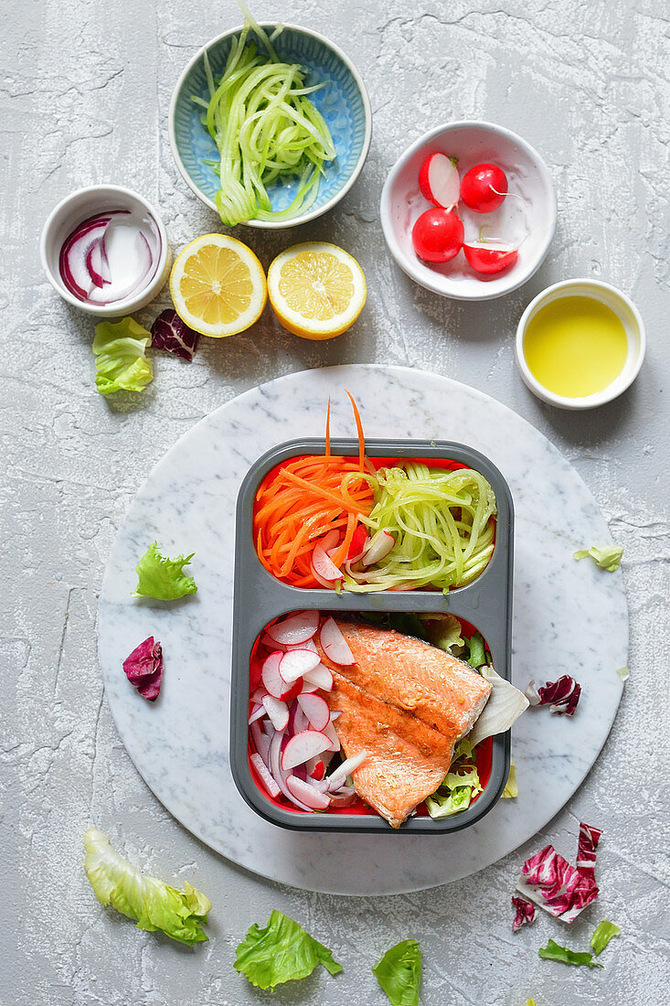 A healthy lunchbox with fish and salad