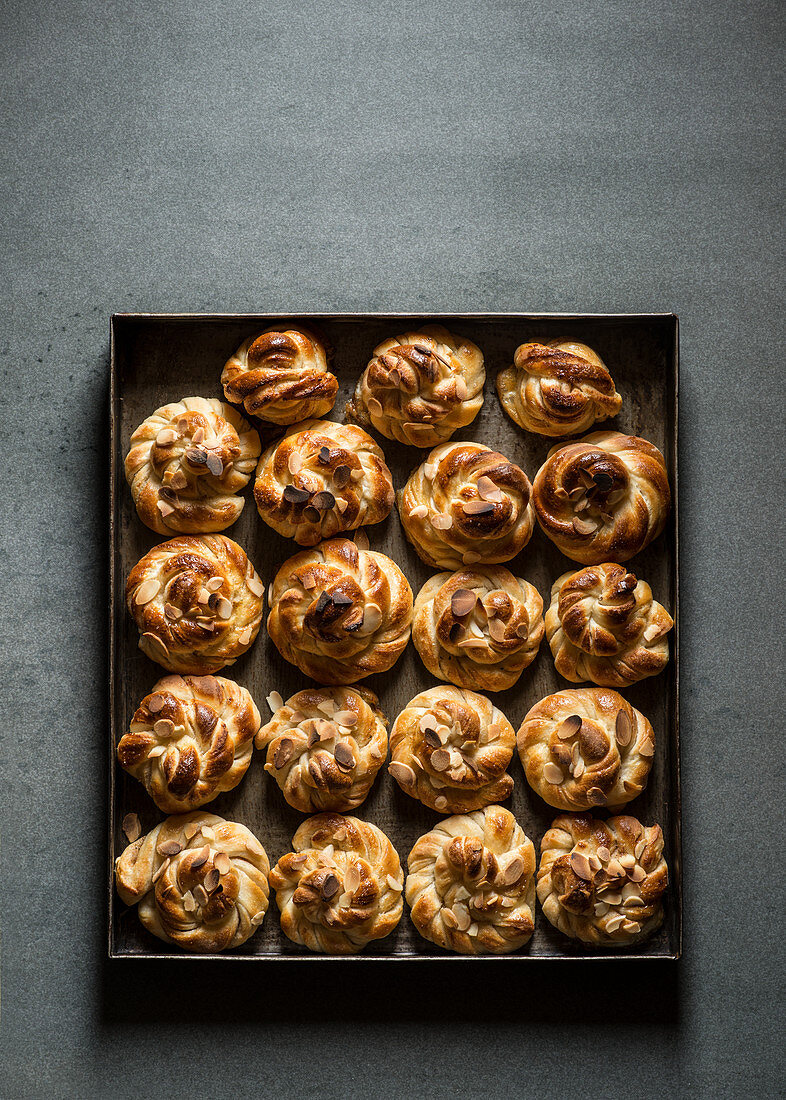 Cardamom Buns in metal tray on grey background