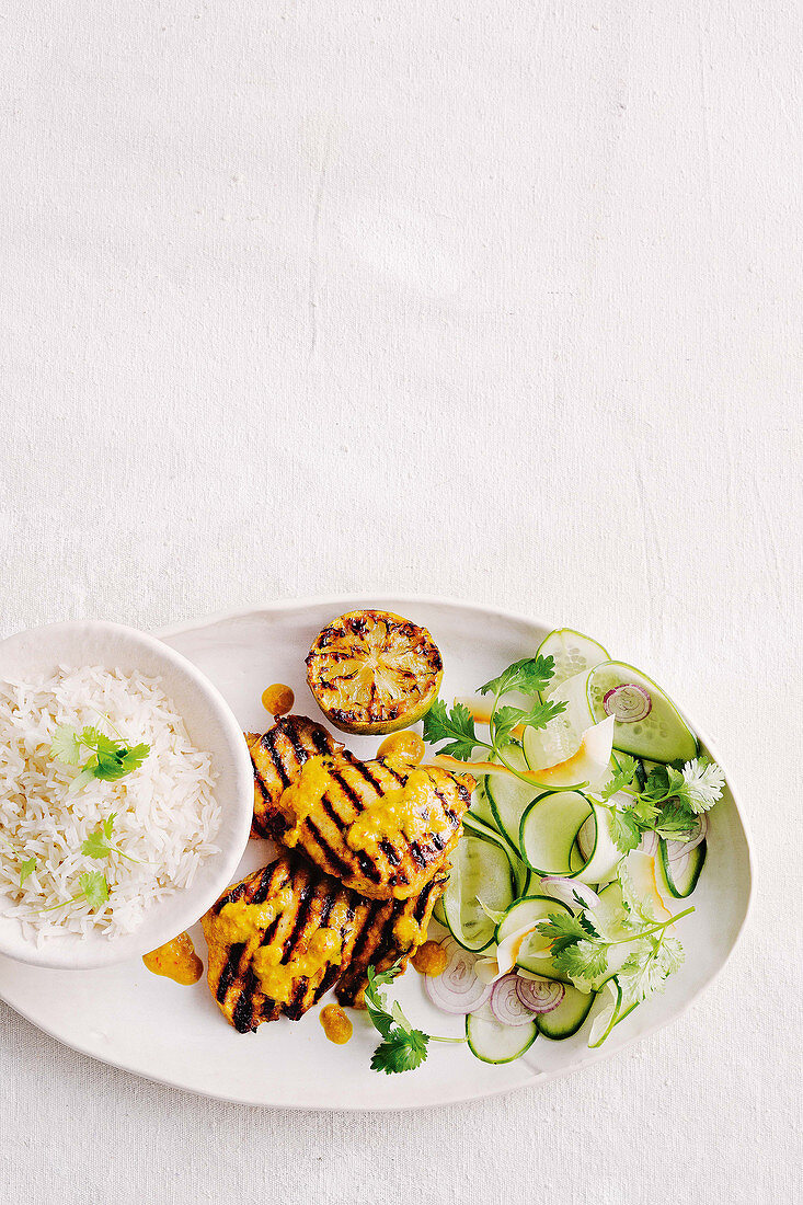 Gegrillte Hähnchenbrust mit Limette und Kokos serviert mit Reis und Gurkensalat