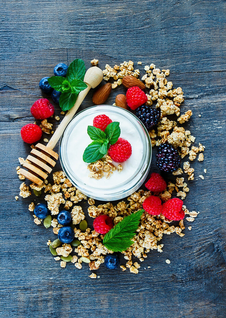 Gesunde Müslizutaten: Joghurt, Granola, Beeren und Mandeln (Aufsicht)