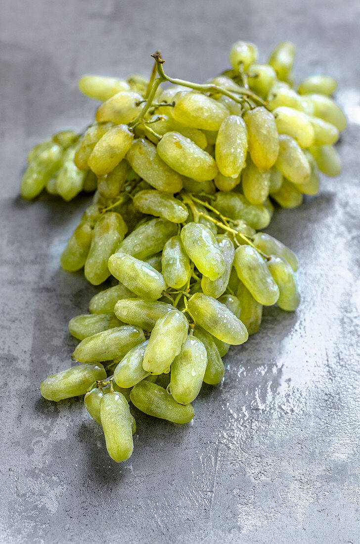 Wet white grapes on a concrete surface