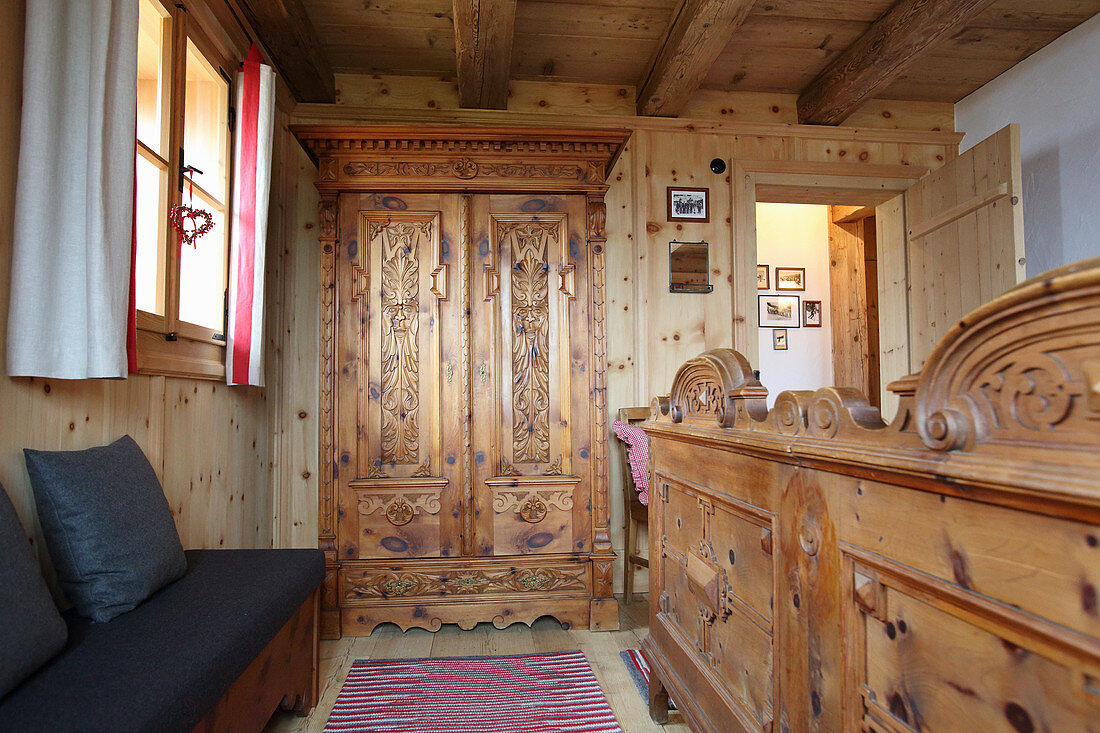 Wardrobe and double bed with wooden foot in chalet bedroom