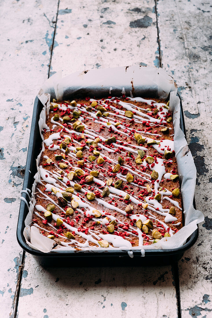 Polenta cake with pistachios, freeze-dried raspberries and lime icing (gluten-free)