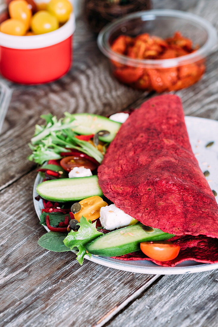 Beetroot wrap with semi-dried tomatoes, greek feta, cucumbers, cherry tomatoes and salad