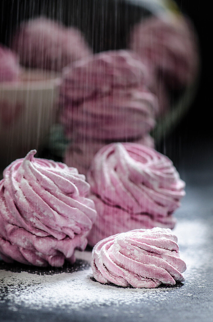 Rosa Zefir mit Puderzucker bestreuen