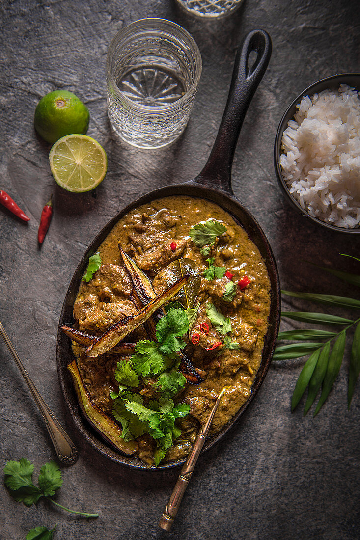 Beef rendang curry, slowly cooked with lemon grass, lime leaves, spices and coconut cream, garnished with crispy aubergine and fresh coriander