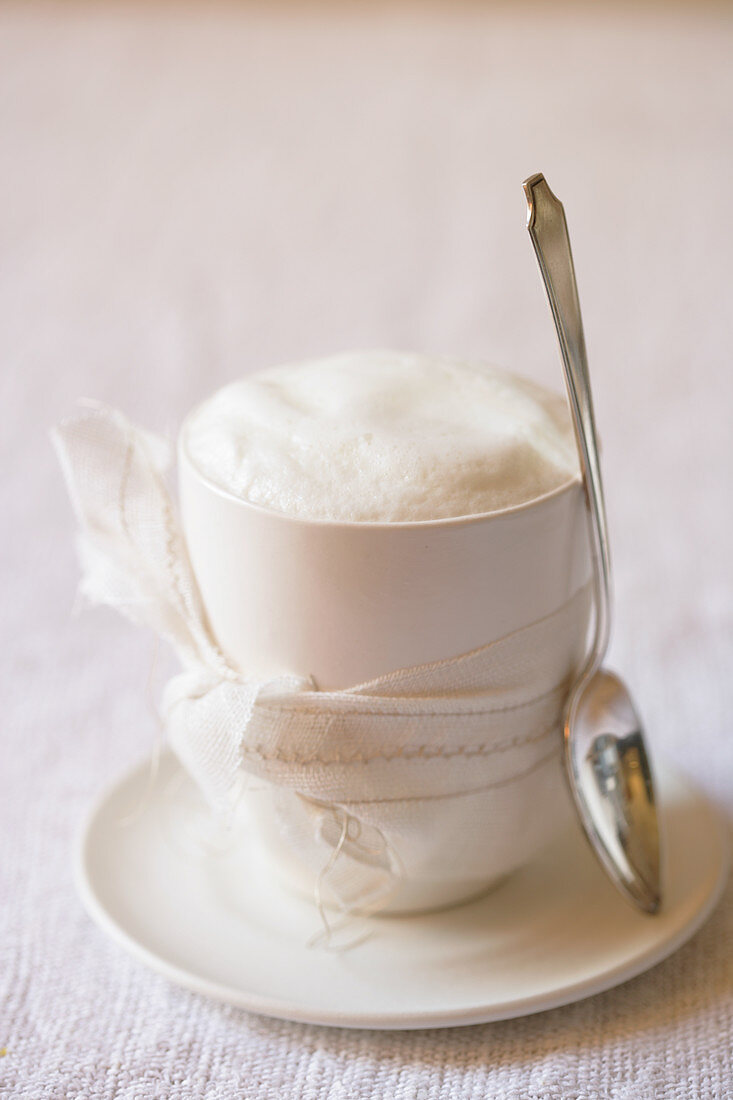 Cappuccino in Tasse mit Schleife und Löffel