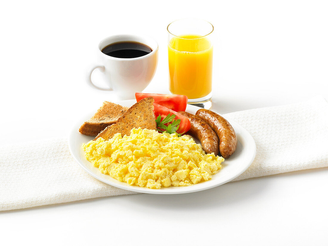 Scrambled eggs with sausages, tomatoes and toast, orange juice, coffee