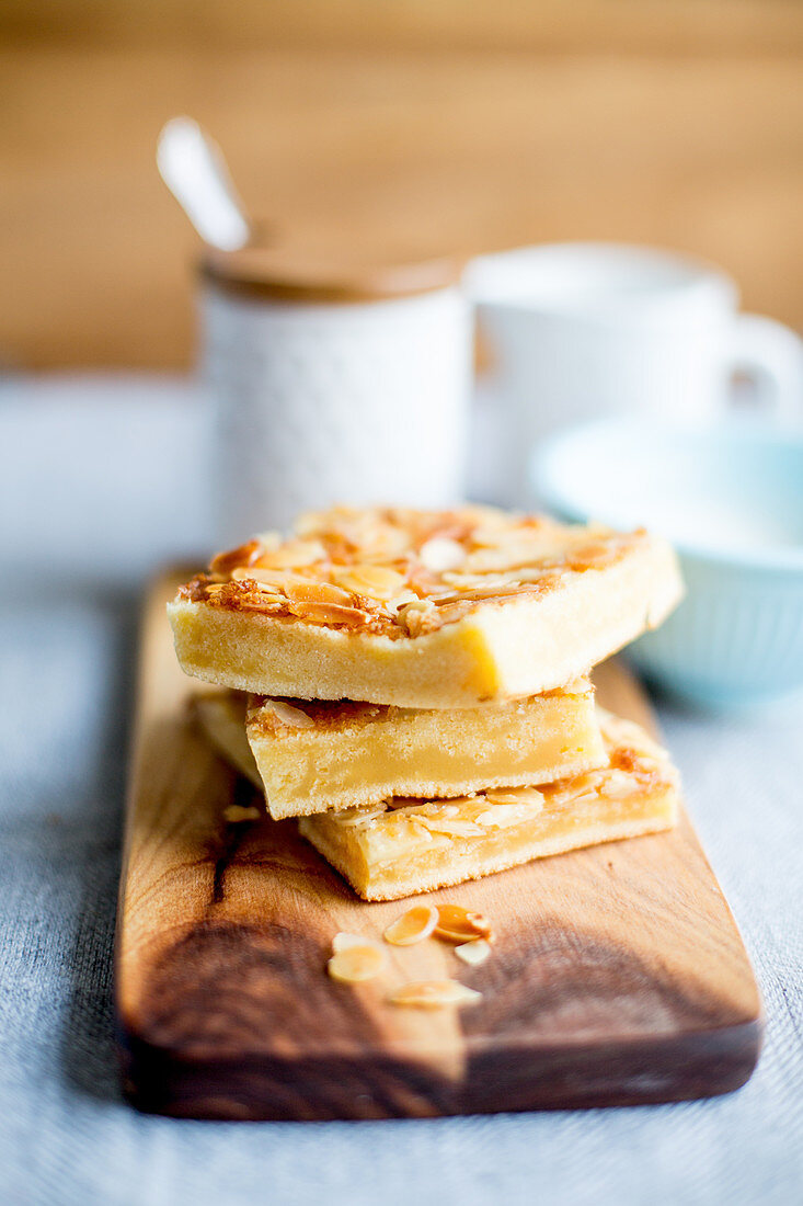 A stack of butter cake slices with flaked almonds