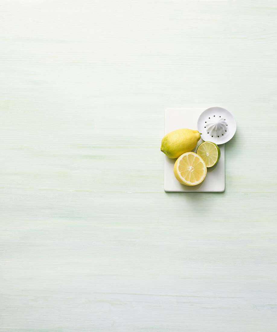 Ganze und halbe Zitrone, Limette und Zitronenpresse