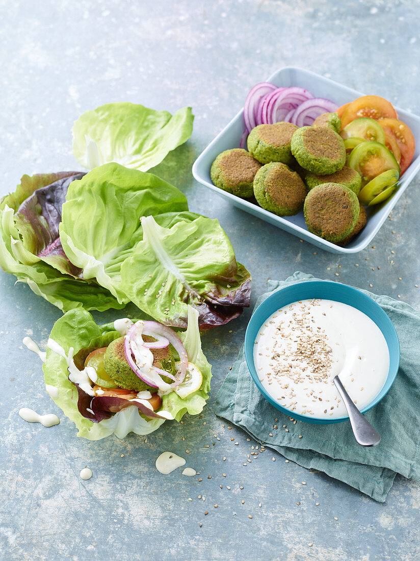 Vegane Kräuter-Falafel serviert in Salatblättern mit Dip