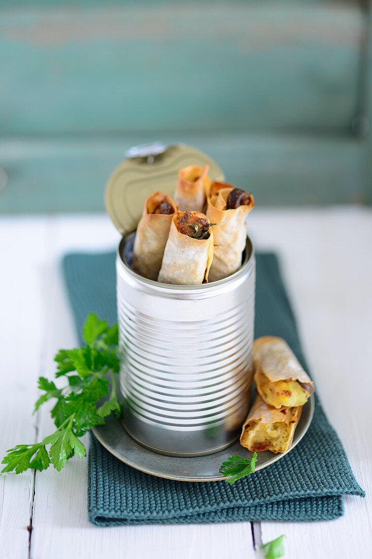 Potato and olive briks with lemon and parsley in a tin can