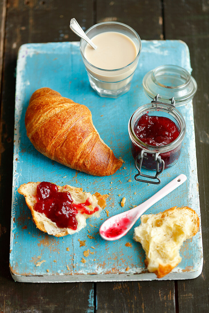 Croissant mit Marmelade und Milchkaffee