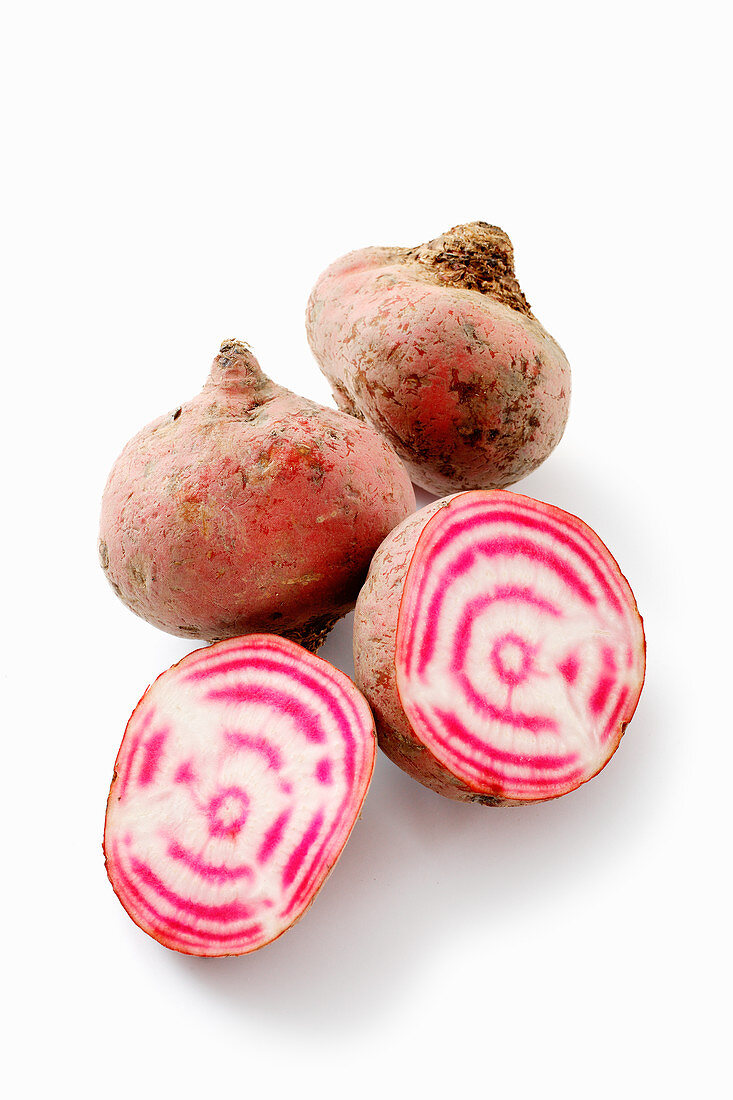 Chioggia beets, whole and halved against a white background
