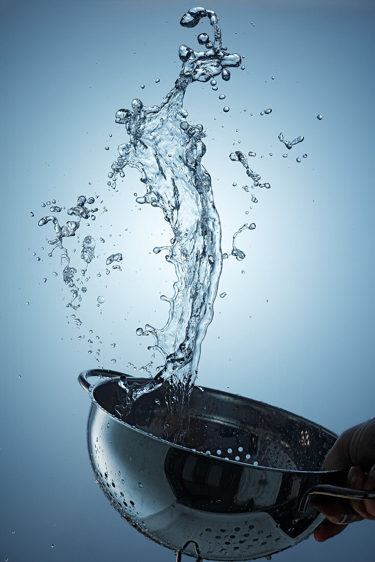 Water splashing from a metal sieve