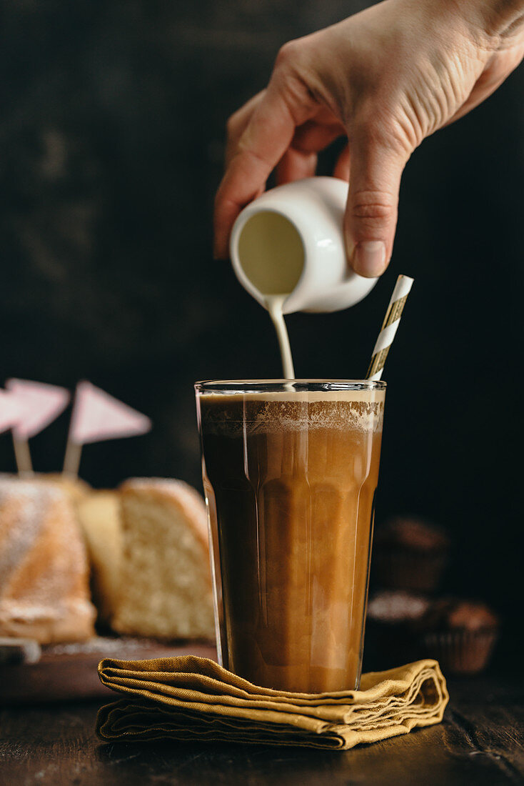 Sahne wird in Kaffee gegossen