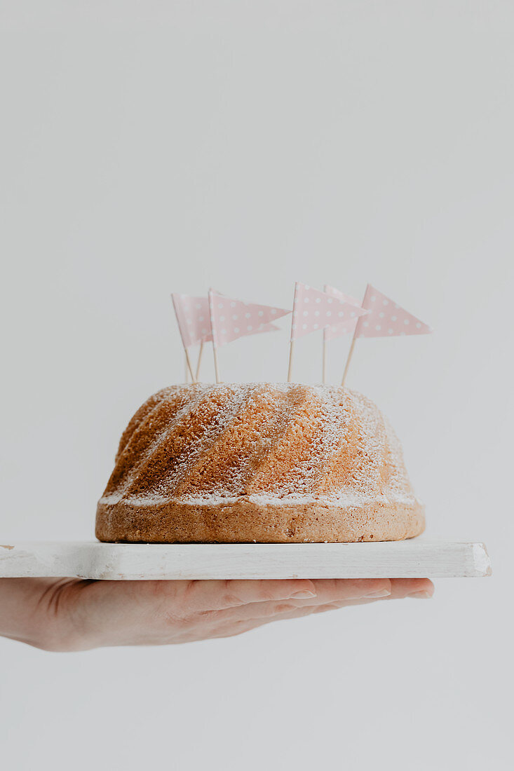 Gugelhupf mit Puderzucker dekoriert mit Papierfähnchen