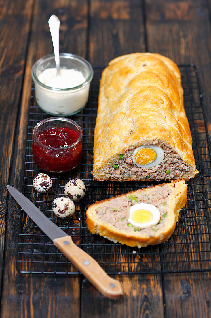 Meatloaf in puff pastry filled with quail's eggs and peas