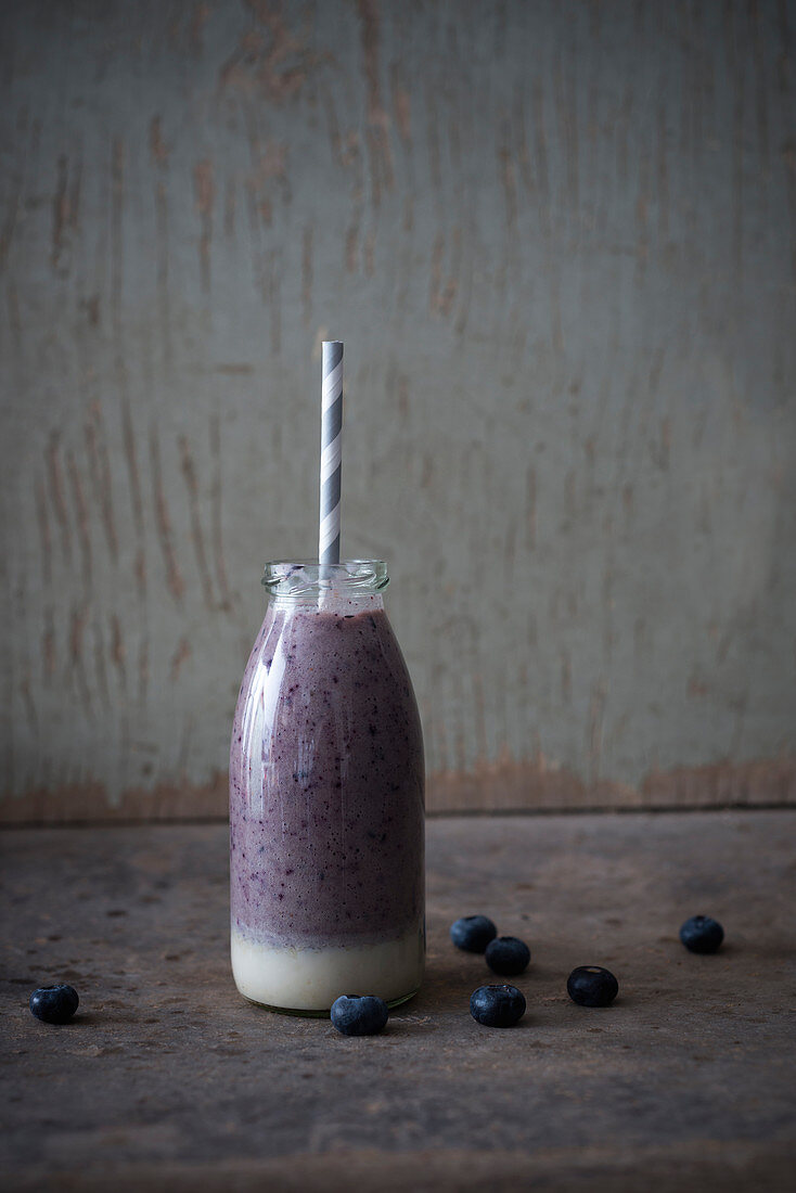 Vegan cashew nut and blueberry smoothie in a glass bottle